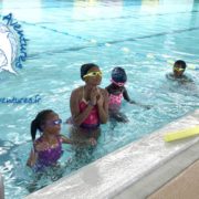 Des enfants barbottent au bord de la piscine